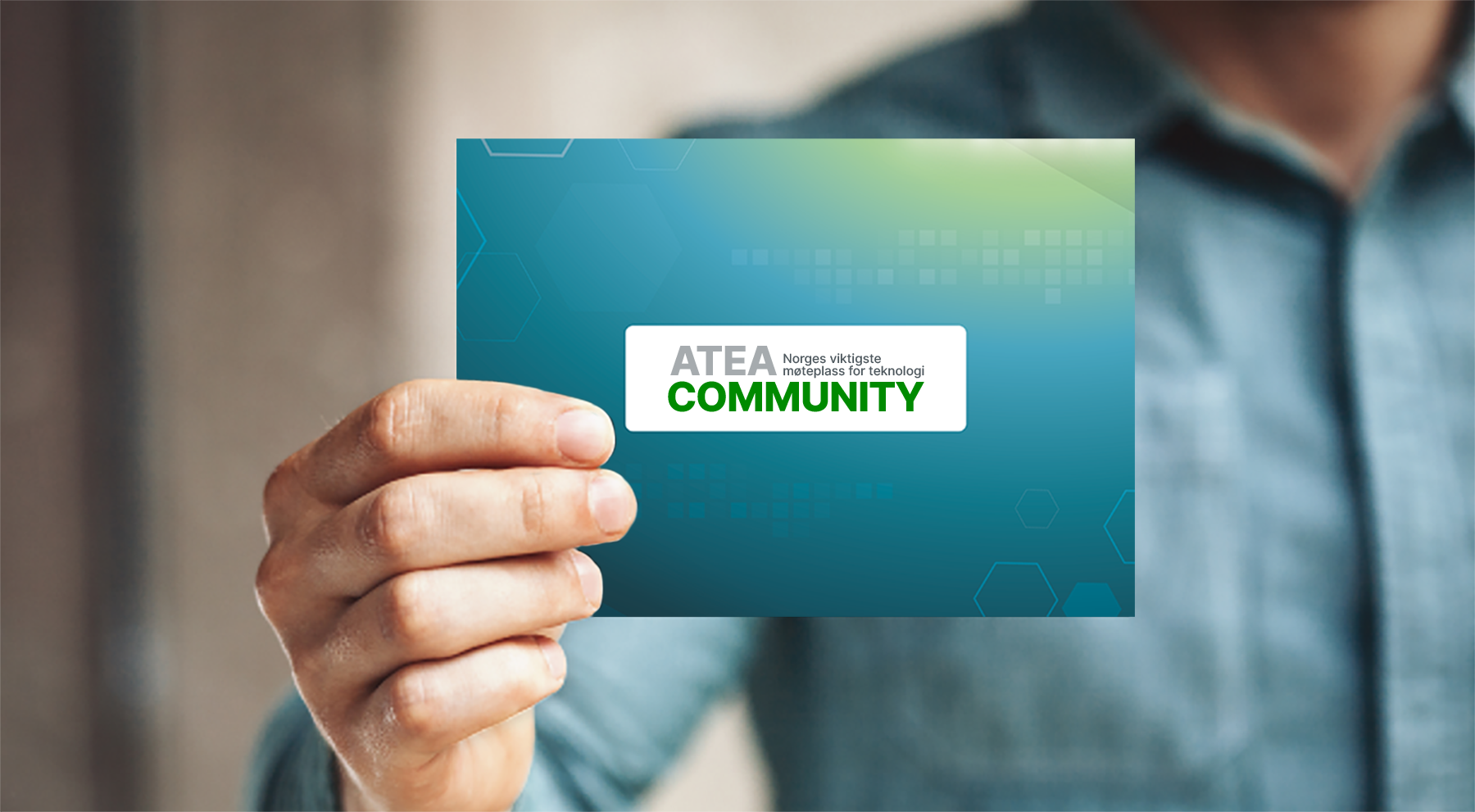 En mann holder i et talekort med Atea Community sin logo
